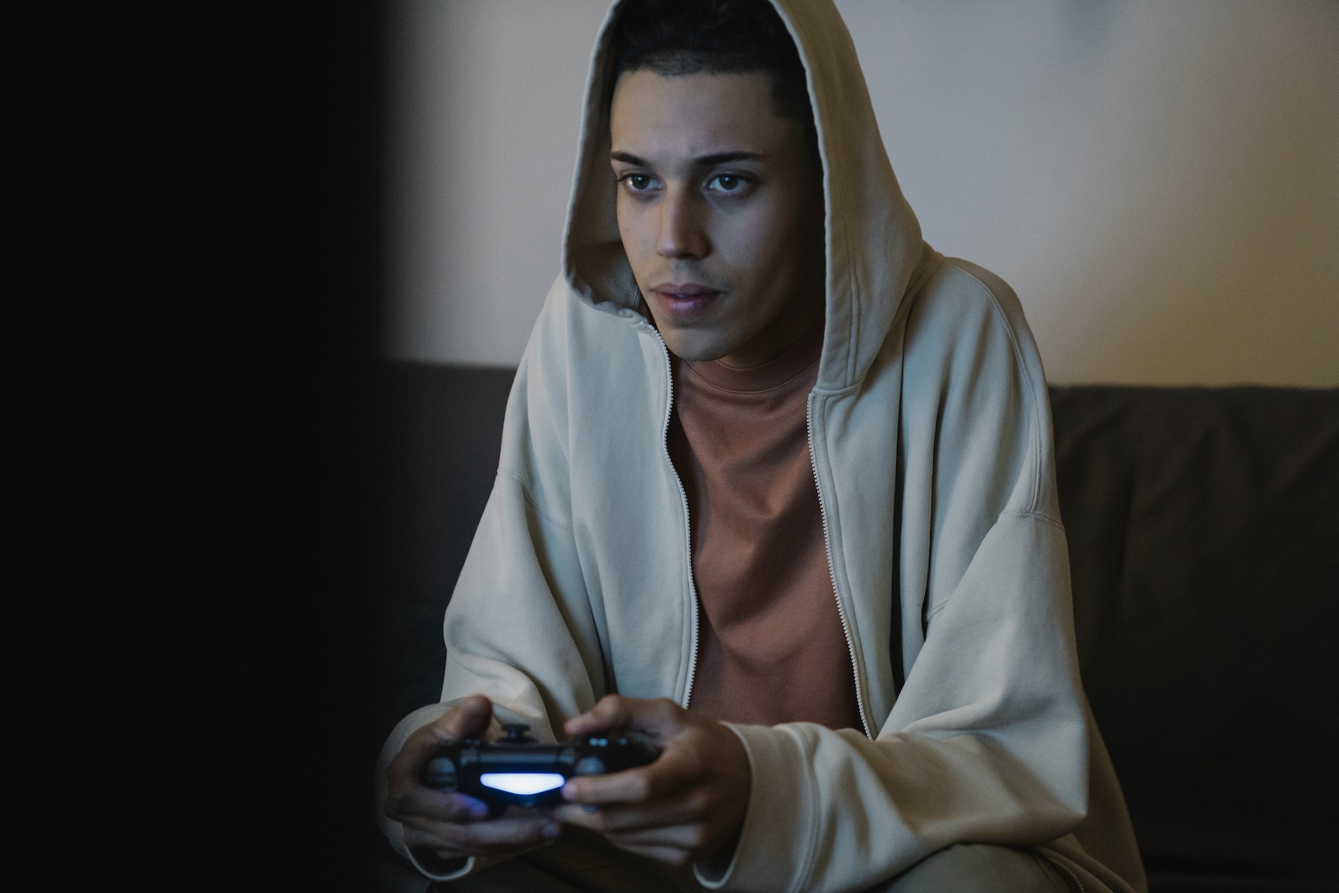 Man with gamepad playing video game in room