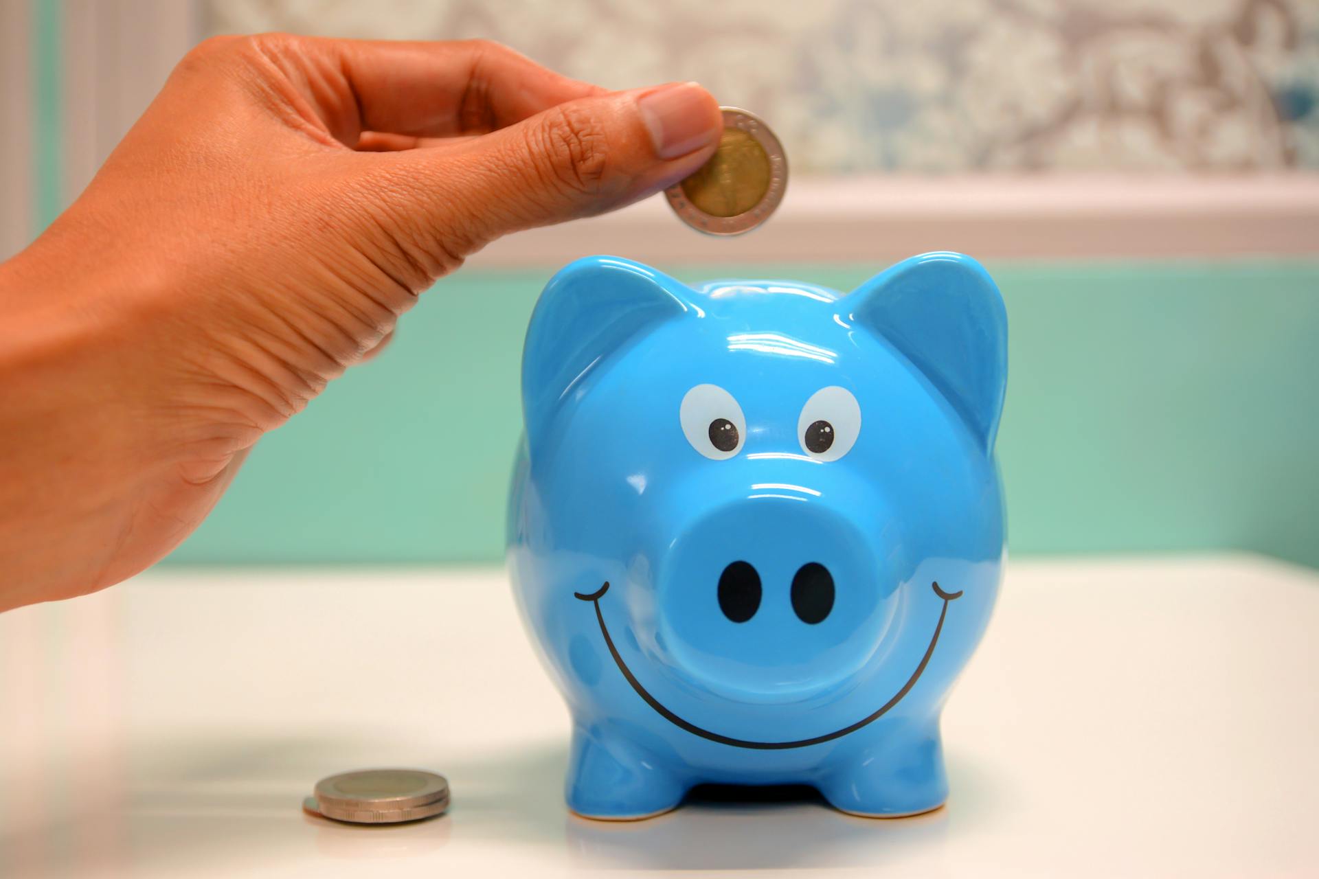 Money going in piggy bank - save money